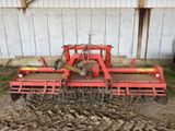 une image représentant un tracteur rouge en train de labourer un champ
