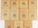 six livres posés sur une table, avec un mur blanc en arrière-plan