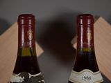 two bottles of wine sitting on top of a table next to each other
