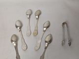 several silver spoons and spoon rest on a white surface