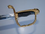 a gold and black sword with a handle on a blue background