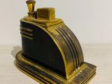 brass plated black and gold money box on a white table