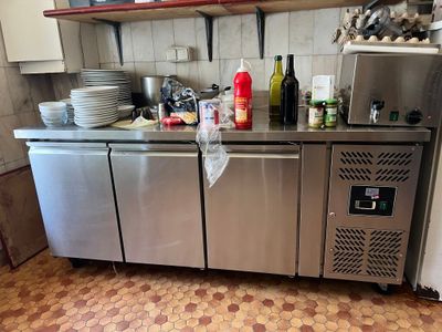 un comptoir en acier inoxydable sur lequel sont posées plusieurs bouteilles