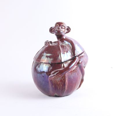 un vase violet sur lequel est perché un singe