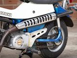 a blue and white motorcycle parked in front of a brick wall