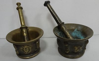 pair of antique brass mortar and pest grinds on a white surface