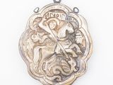 a silver medal with a picture of a woman riding a horse