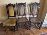 Trois chaises anciennes sont alignées contre un mur dans un salon