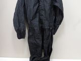 un imperméable noir et une paire de chaussures posés sur une table blanche