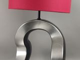 une lampe surmontée d'un abat-jour rose