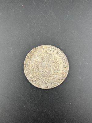 gros plan d'une pièce de monnaie en argent sur une surface noire