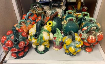 a pile of ceramic figurines sitting on a white shelf