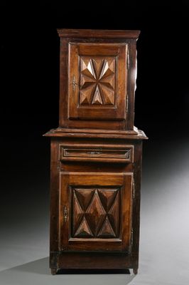 une vieille armoire en bois à deux portes, surmontée d'une horloge