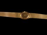 a close up of a gold watch on a black background