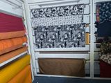 a lot of different fabrics on the shelves in the room