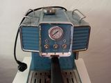 a blue coffee machine sitting on top of a white table