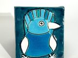 a blue and white bird on a blue and white tile