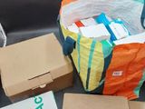 de nombreuses boîtes et un sac posés par terre à côté d'une chaise