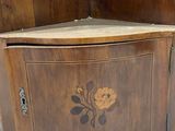 a wooden corner cabinet with a mirror on top of it
