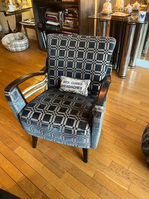 a chair that has a pillow on it in a living room