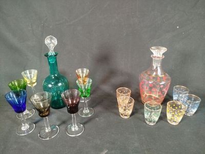 many different colored glasses and vases sitting on a table