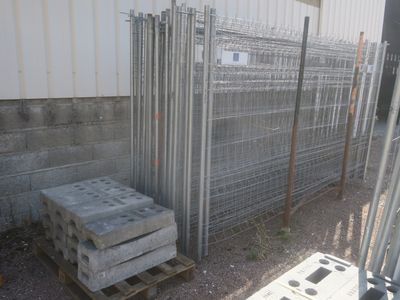 une pile de parpaings posée sur une palette devant un bâtiment