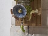 a vase that has flowers in it hanging on a wall