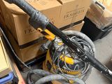 a yellow and black vacuum on the floor next to a pile of boxes