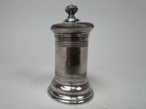 an antique silverplated salt shaker on a white background