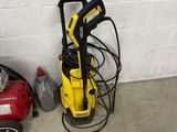 a yellow pressurer sitting next to a red and black vacuum