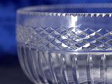 a clear glass bowl sitting on a table with a blue background