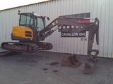 a small excavator that is parked in front of a building