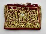an image of a red and gold embroidered purse with a tag on it