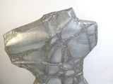 une sculpture représentant un torse en verre posée sur une table