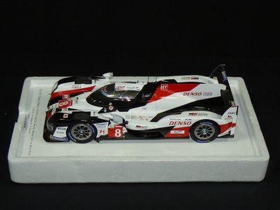 une maquette de voiture de course posée sur un plateau blanc