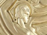 a close up of a gold plate with a woman on it