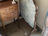 un lit et une commode dans une pièce où une lampe est allumée
