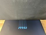 the laptop is sitting on a wooden table with a black wall behind it