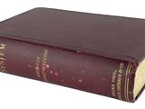un vieux livre brun posé sur une surface blanche