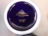 a blue and white bowl with a gold writing on it