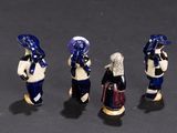 three figurines of people dressed in blue and white standing next to each other