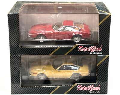 lot de deux petites voitures moulées sous pression, une rouge et une jaune, dans une boîte