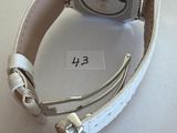 wrist watch with white leather strap on white surface with price tag
