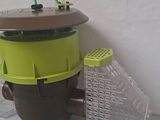 a brown and green trash can next to a white wall