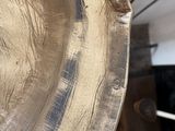 a close up of a metal plate with a wooden handle