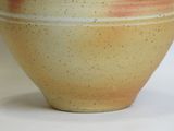a brown and white vase sitting on a white surface