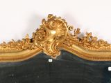 a mirror with a gold frame on a white wall
