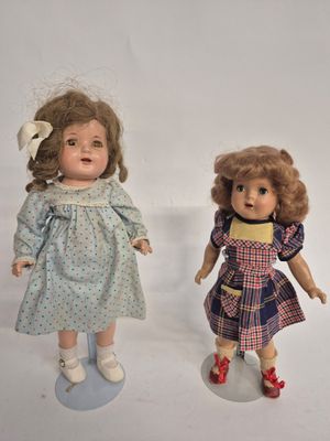 two dolls that are standing next to each other