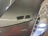 a close up of a car ' s headlight with a sticker on it