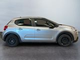 the small silver car is parked in a room with a white wall